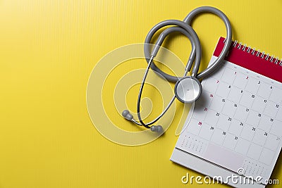 Stethoscope and calendar on the yellow background, schedule to check up healthy concept Stock Photo