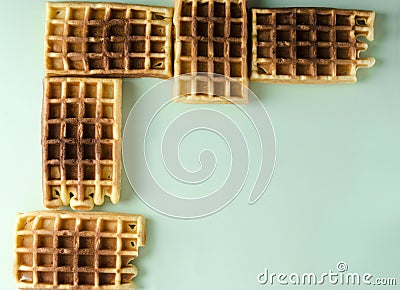 Top view of tasty sweet waffles on the green background.Line of waffles like dominoes Stock Photo