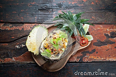 Top view Thai food pineapple chicken fried rice on rustic wooden table Stock Photo