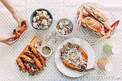 Top view of Thai Seafoods are Grilled Prawns Shrimps in the shell, Steamed crabs, grilled Laevistrombus Canarium, Grilled Squid. Stock Photo