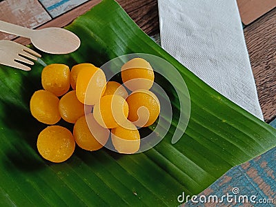 Top view, Thong Yod or Round Egg Yolk Tart, an ancient Thai dessert, orange and gold, has a sweet taste on banana leaf Stock Photo