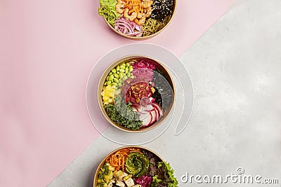 Top view of three plates full of diet dishes on a grey and pink background- vegan food concept Stock Photo