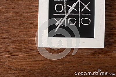 Top view of tic tac toe game on blackboard with crossed out row of crosses Stock Photo