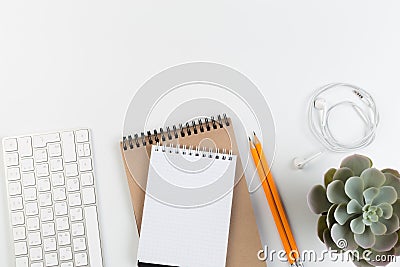 Top View of trendy White Office Desk with keyboard, white earphones and office supplies Stock Photo