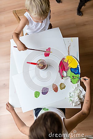 Top view of two children painting with watercolors with brush an Stock Photo