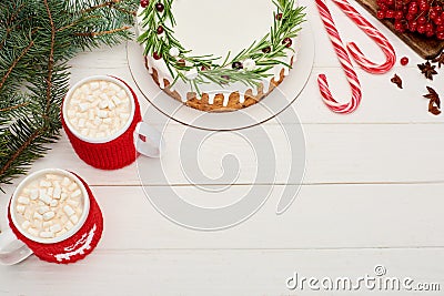 Top view of two cups of cocoa with marshmallows and christmas pie with icing on white wooden table. Stock Photo