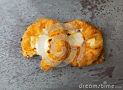 Top view of two delicious cream cheese danishes with one missing a bite on a gray mottled tabletop Stock Photo