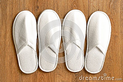 Top view two pairs white slippers in the hotel on wooden floor Stock Photo