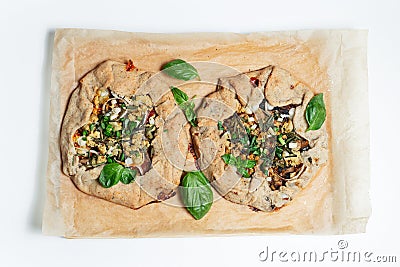 Top view of two vegan galettes on parchment paper. White background. Homemade food. Stock Photo