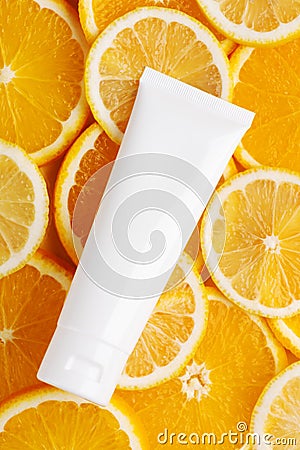 Top view of unbranded bottle for cosmetics product. Plastic flacon for cream, body lotion or toiletry. Juicy slices of orange and Stock Photo