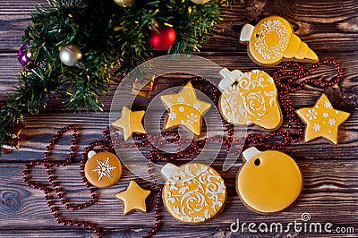 Top view on variety of yellow glazed ginferbread cookies laying near christmas decorations on wooden background Stock Photo