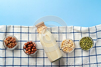 Top view of vegetable milk bottle with bowls of nuts Stock Photo