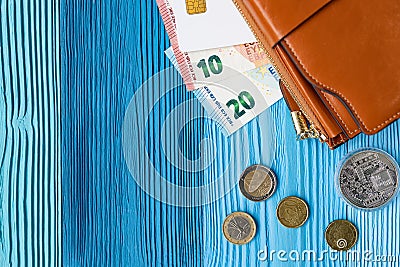 Top view of wallet, coins, banknote and card on the light blue wooden background texture. Stock Photo