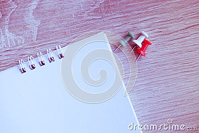 Top view of white blank paper desk spiral calendar with colorful pins on wooden background Stock Photo