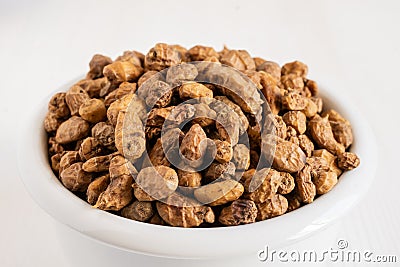 Top view of white bowl with tiger nuts, white blank background, selective focus, Stock Photo