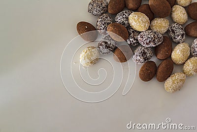 Top view of white, dark and cocoa Chocolate almonds on white table Stock Photo