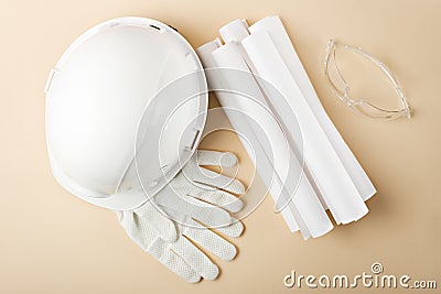 Top view white helmet, gloves, plan, drawings, construction glasses on beige background, development of construction object Stock Photo