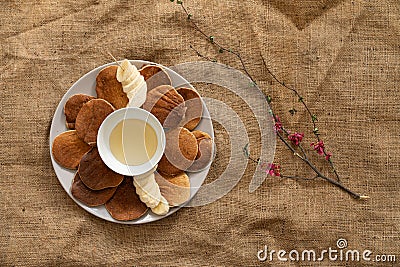 Top view of a white plate with pancakes honey and banana de orated with tender branch with flowers Stock Photo