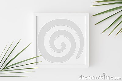 Top view of a white square frame mockup with palm leaf decoration Stock Photo