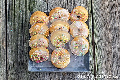 Top view on white sugar glazed mini donuts on a sheet metal tray Stock Photo