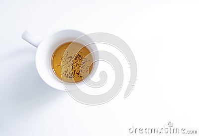 top view of a white tea cup on a white background with some tea infusion and tea grounds in the bottom of the cup, roiboos, Stock Photo