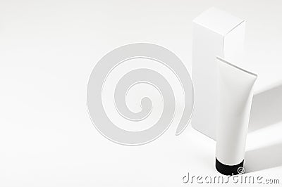 Top view of white unbranded tube with black cap and packaging box. Blank flacon for cream, sunscreen or moisturizing lotion on Stock Photo