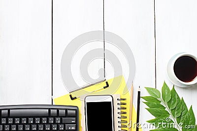 Top view white wooden desk table with keyboard smartphone supplies and coffee cup and have copy space. Stock Photo