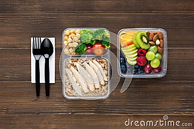 Wholesome nutrient rich food set in take away boxes with spoon and fork on wood table ready to eat Stock Photo