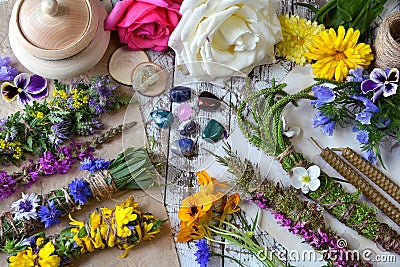 Top view of witchery scrolls with magic herbs, summer flowers and crystals on table Stock Photo