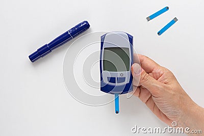 Top view of woman hand holding glucose meter with blooded test strip with empty screen to fill your datas on white background Stock Photo