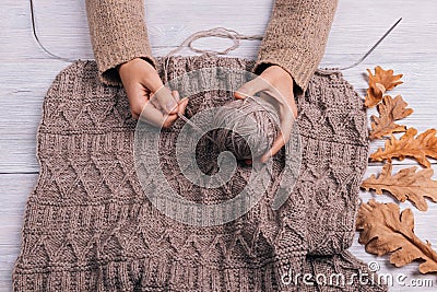 Top view of a woman's hands holding a ball of wool yarn on a tab Stock Photo