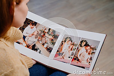 woman watches photobook from photo shoot of married couple during pregnancy. Stock Photo