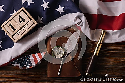 Top view of wooden calendar with October 14 date, paper boat, nib, compass, telescope and leather notebook Stock Photo