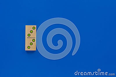 Top view of wooden dominoes gaming double piece with three spots on with copy space on the blue background Stock Photo