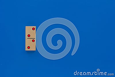 Top view of wooden dominoes gaming double piece with two spots on with copy space on the blue background Stock Photo