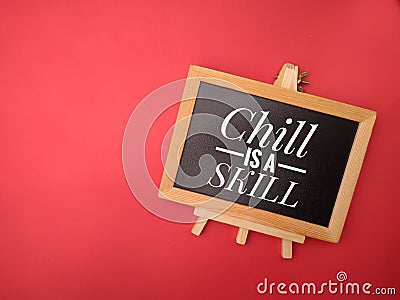 Top view of wooden frame with the word Chill is a skill on red background Stock Photo