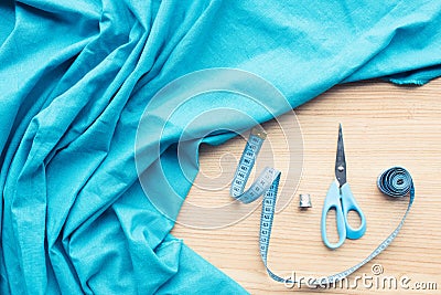top view of wooden table with blue fabric, scissors, measuring tape Stock Photo