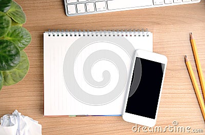 Top view of working space with smartphone over a blank notepad Editorial Stock Photo
