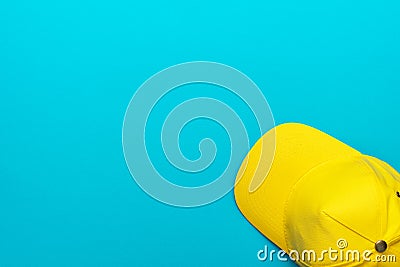 Top view of yellow baseball cap over blue turquoise background with copy space Stock Photo