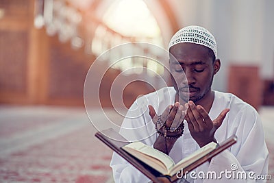 Top viewv of African Muslim Man Making Traditional Prayer To God While Wearing A Traditional Cap Dishdasha Stock Photo