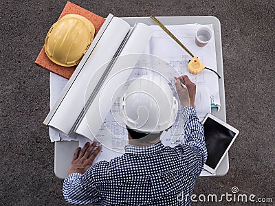 Top viwe, Engineers in helmets planning new project on table. Architect working on blueprint Stock Photo