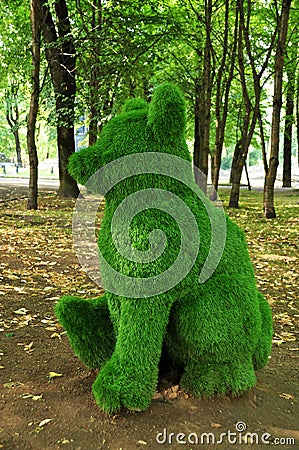 Topiary. Trimmed green bushes, a seated bear figurine. Editorial Stock Photo