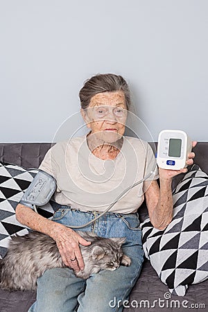 The topic very old person and monitor health. senior Caucasian woman, 90 years old, with wrinkles and gray hair, sits Stock Photo