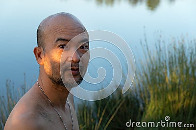 Topless bald beard Asia man with outdoor lake nature background Stock Photo