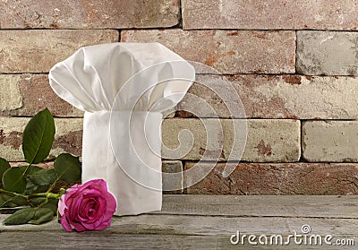 Toque with pink rose on brick wall Stock Photo