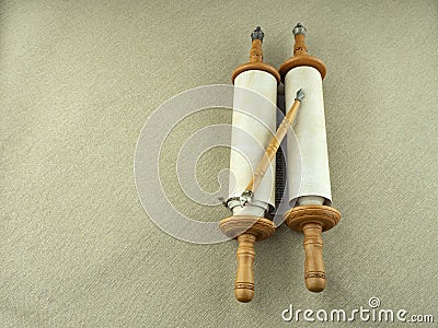 Torah scrolls on wooden tables, a symbol of Judaism, against a background of gray linen canvas. Stock Photo