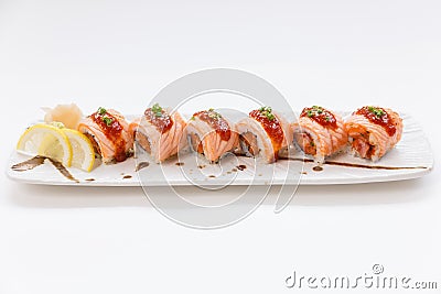 Torched Salmon Maki Roll with Raw Salmon Inside Topping with Sauce and White Sesame . Served with Slice Lemon. Wasabi and Prickle Stock Photo