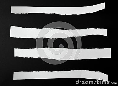 torn blank white paper strips against a black background Stock Photo