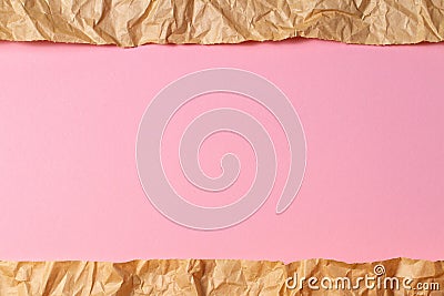 Torn crumpled recycled brown paper on light pink colored paper background inside Stock Photo