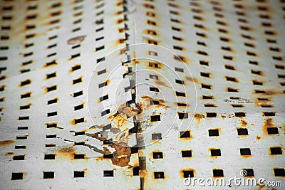Torn metal plate with perforation coated with corrosion Stock Photo